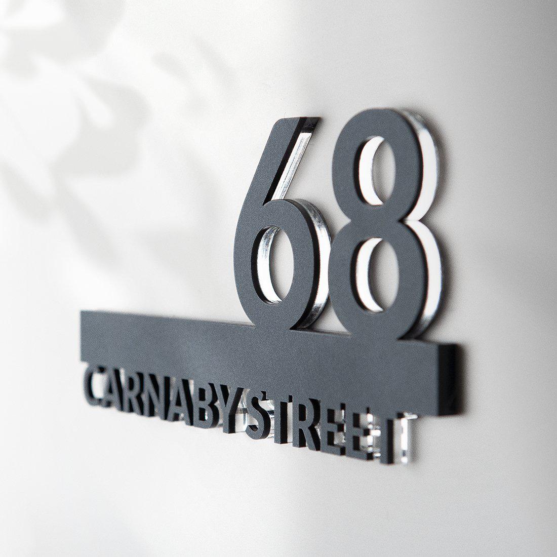 Bel numero civico 68 vista laterale. Sotto  evidenziato il nome della via: Carnaby Street